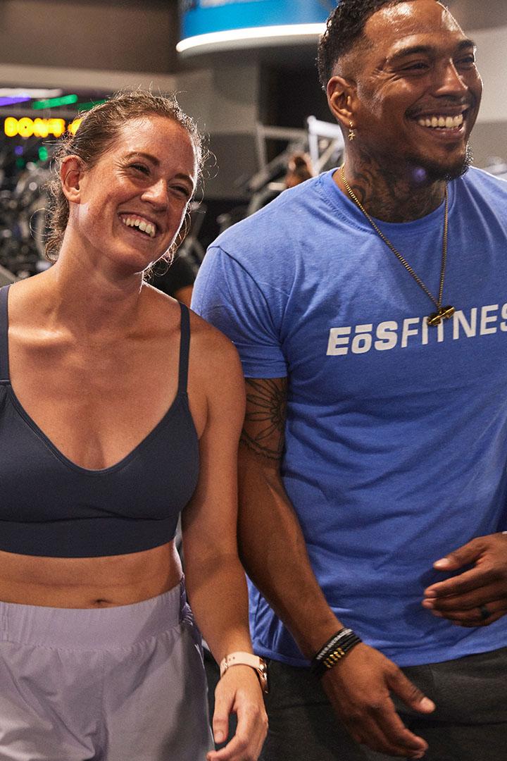 Two gym members smiling and standing together