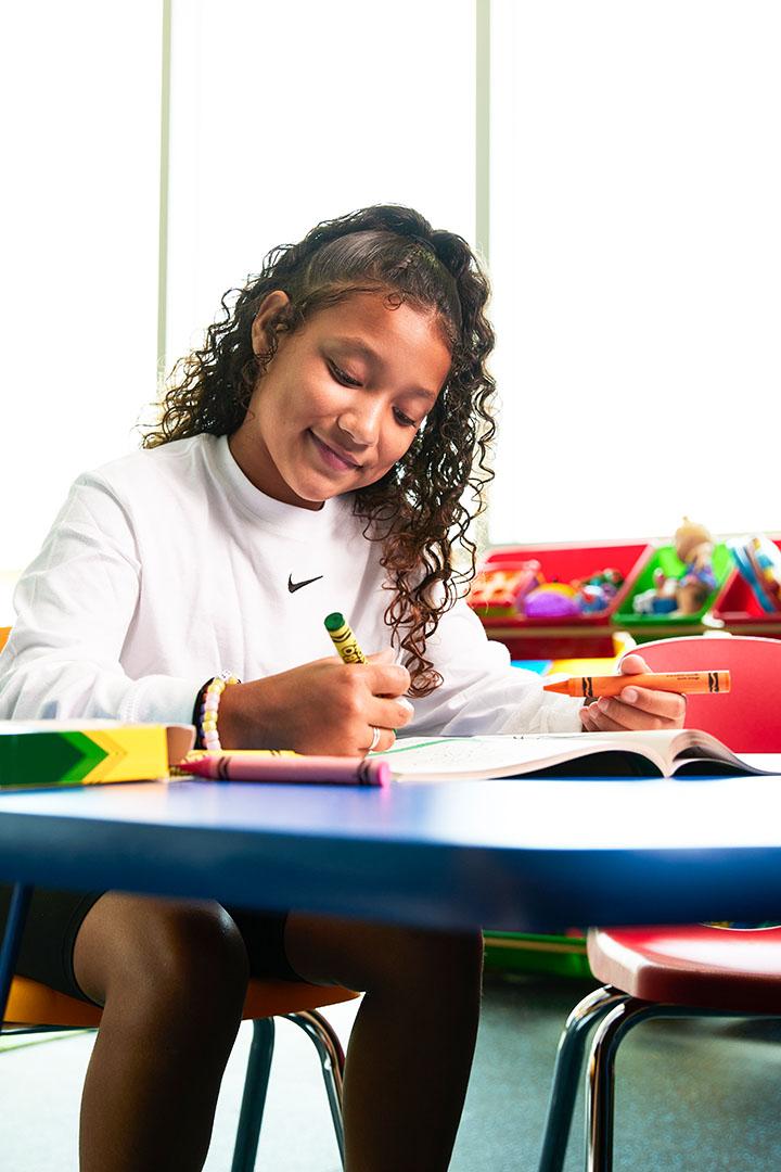 Girl drawing with crayons