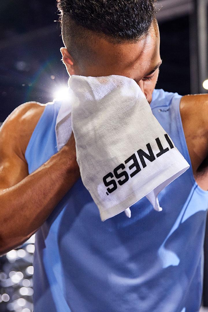 Gym member wiping sweat with a towel