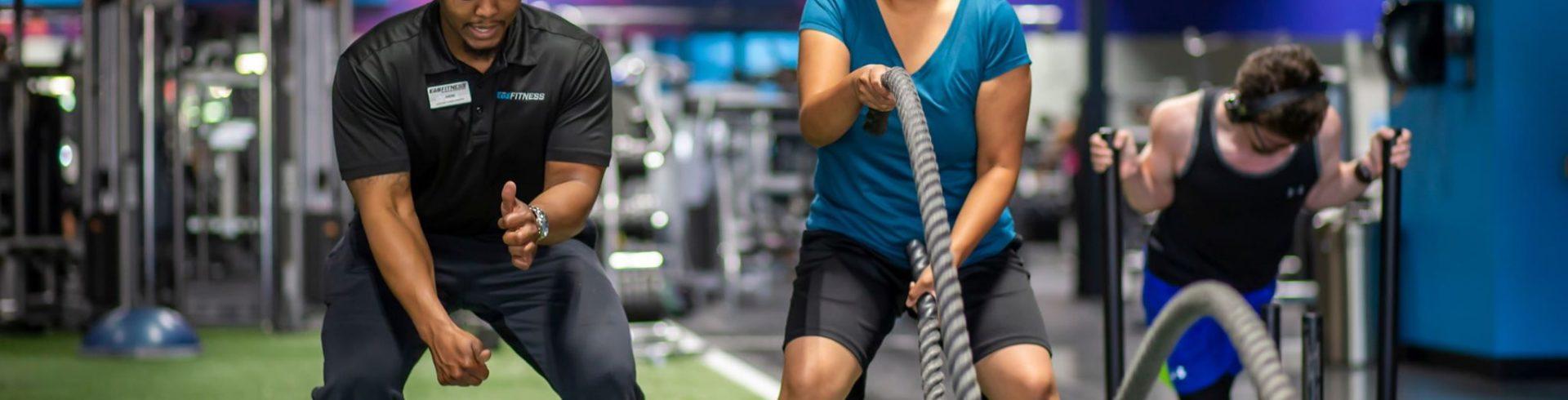 personal trainer showing eos gym member Proper Technique on battle ropes