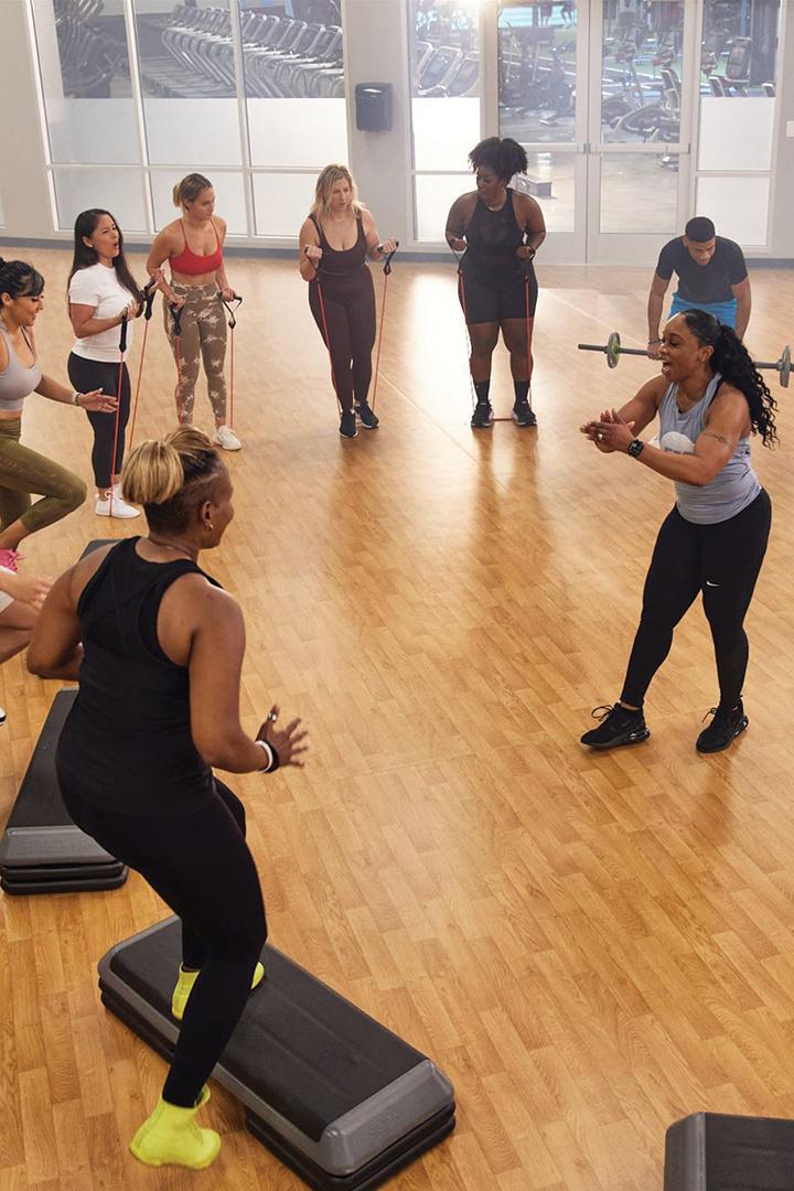 group of energetic eos gym members working out together is modern studio