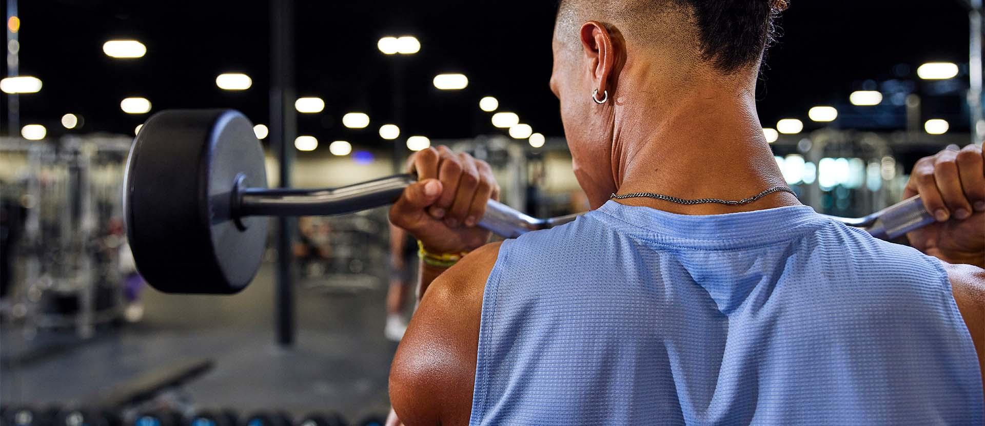 eos gym member curling a barbell looking at a large mirror