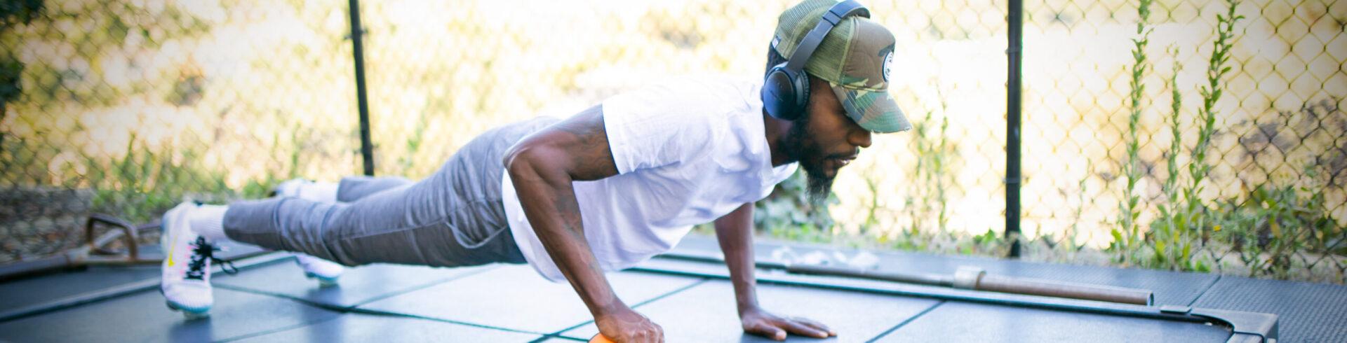 man in a gym doing a plank in an outdoor gym