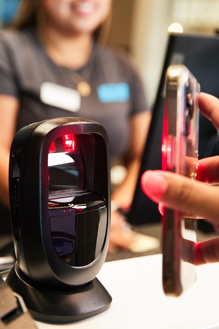 close up shot of phone scanning at the front desk to check in