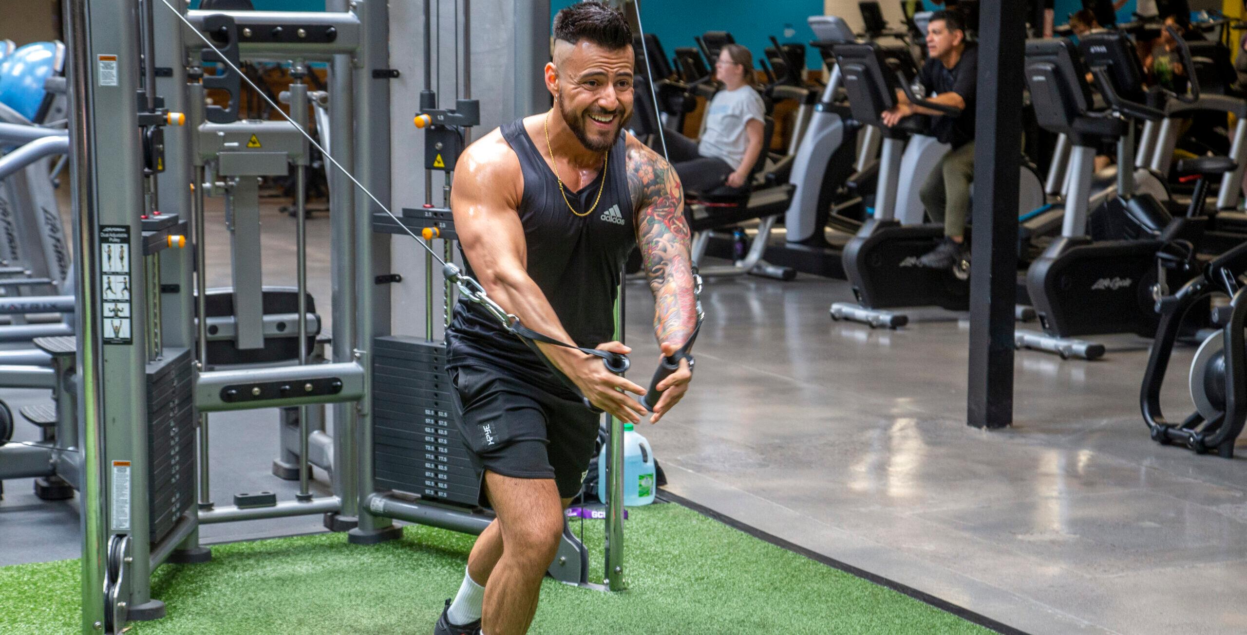 athletic eos gym member working on a cable fly machine