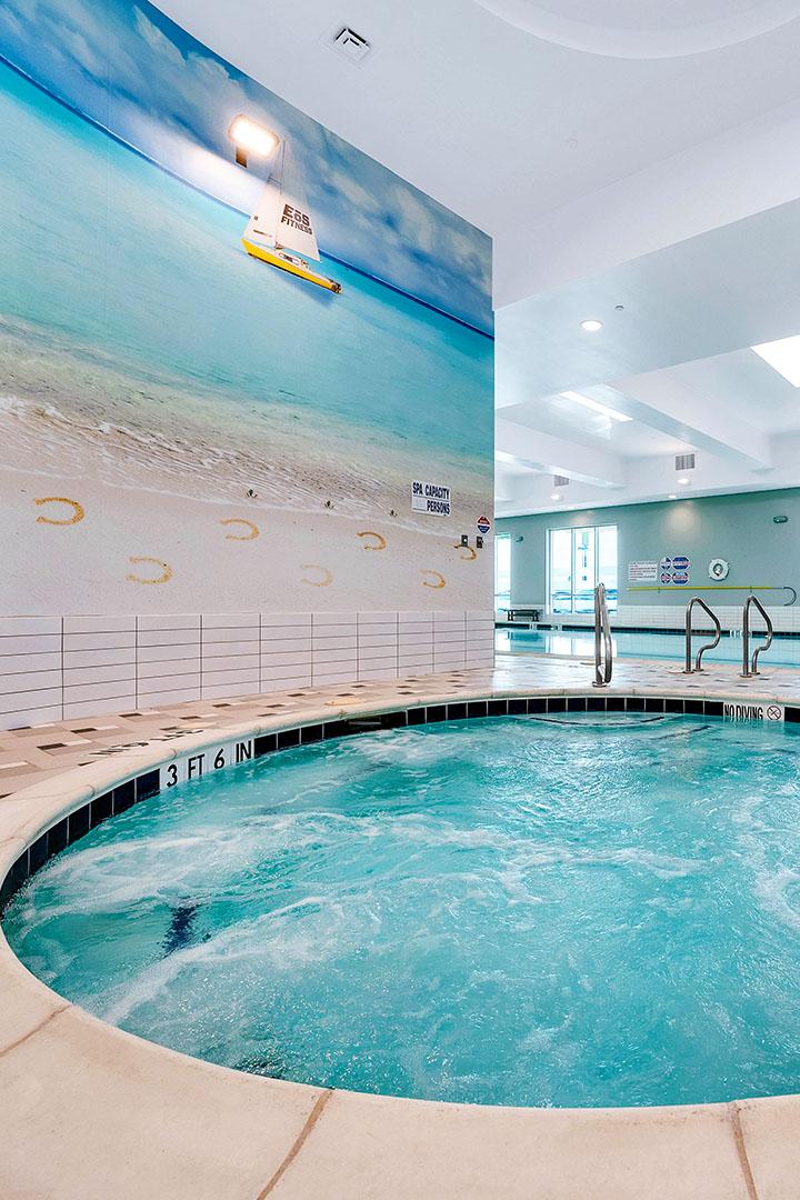 Indoor hot tub and beach mural on wall