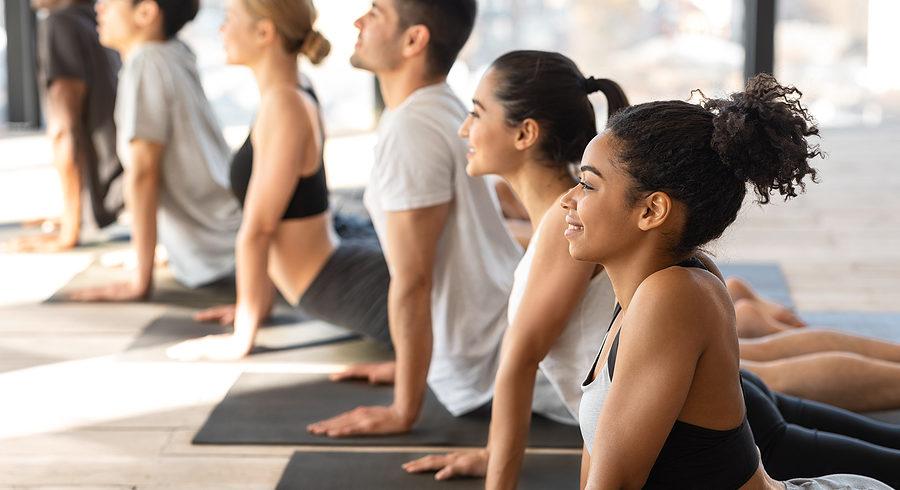 men and women practicing yoga at a gym