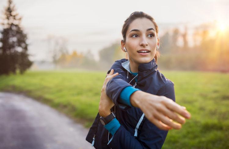 athletic eos gym member stretching arm outside