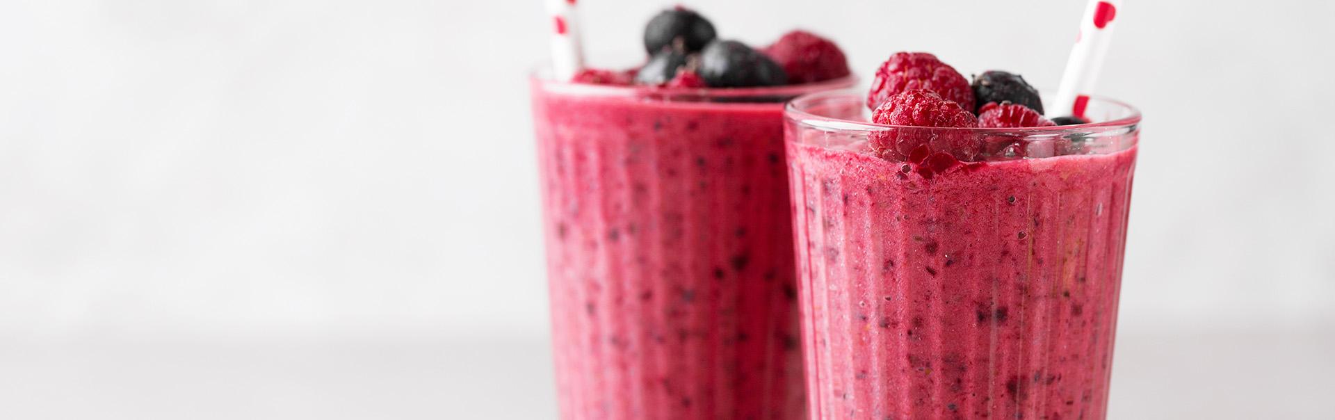 two full glasses of mix berry smoothie with razzberries and blueberries 