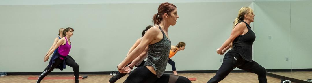 eos gym members doing yoga together in a modern studio