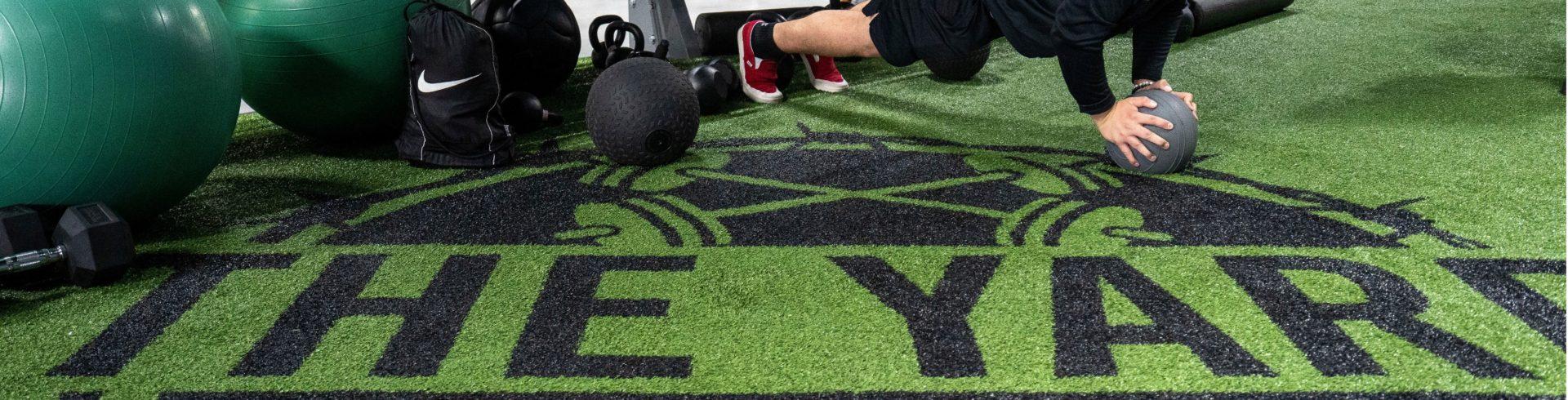 eos gym member doing pushup variations in eos branded turf