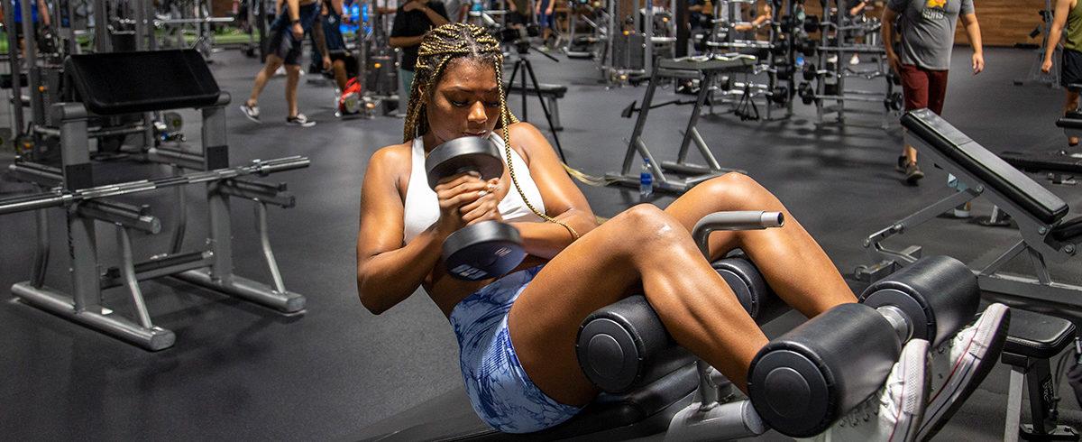 athletic eos gym member doing dumbbell crunches