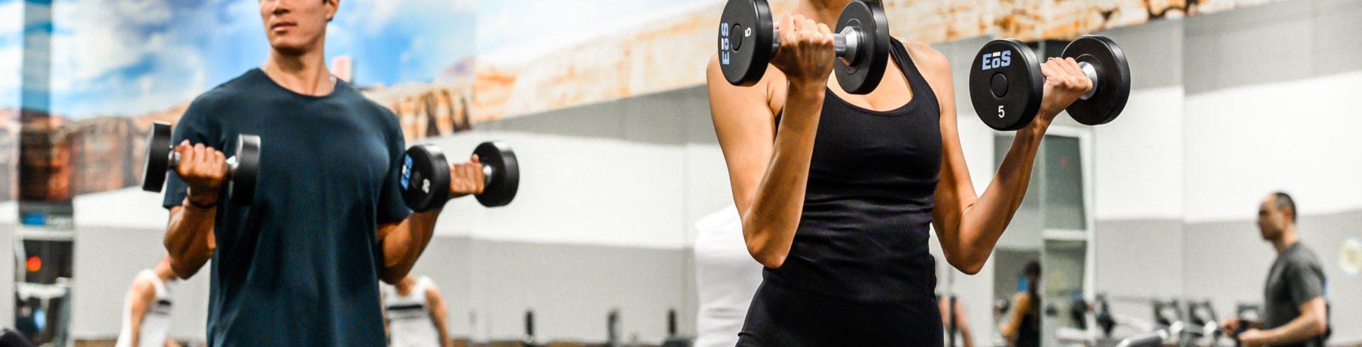 two eos gym members during curls in an eos branded box gym