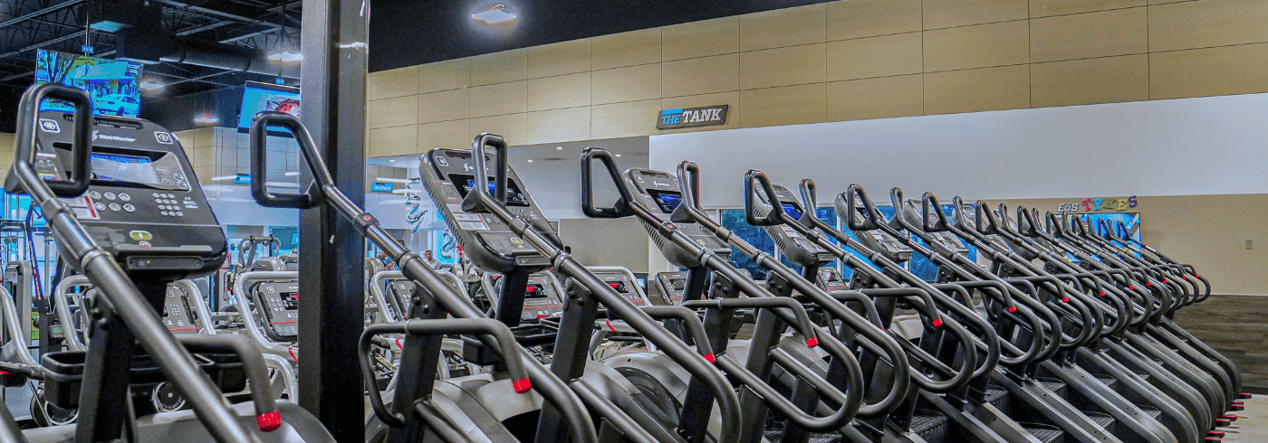 a row of EōS Fitness Stairmaster gym equipment