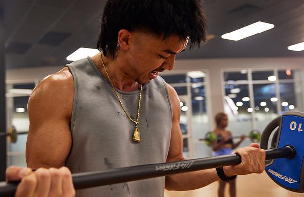 close up of muscular eos gym member doing curls in modern studio