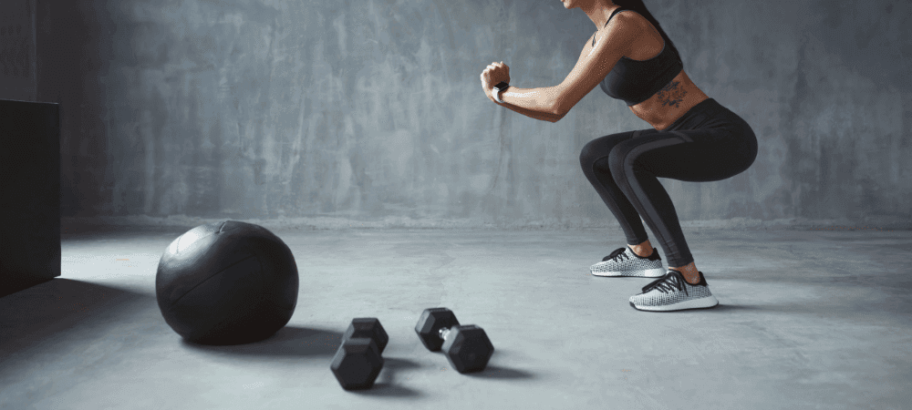 athletic person doing body squat in an industrial exercise room