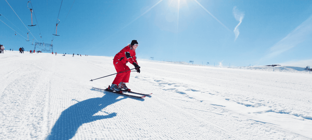 athletic person skiing down white slopes