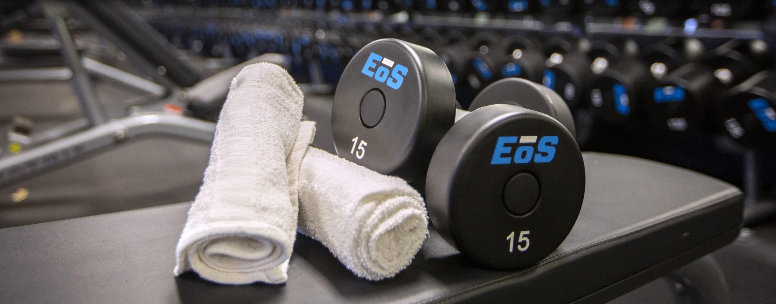 close up shot of eos branded towels and dumbbells 