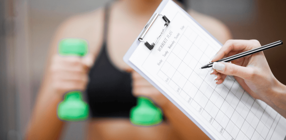 personal trainer writing down a workout plan for eager eos gym member